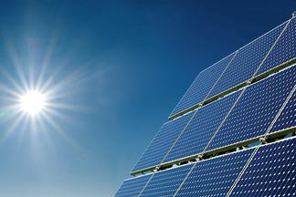 PV-Modul mit Himmel  und Sonne im Hintergrund