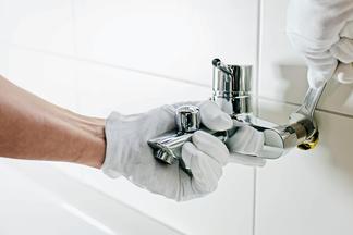 Handschuh-Hand an Armatur